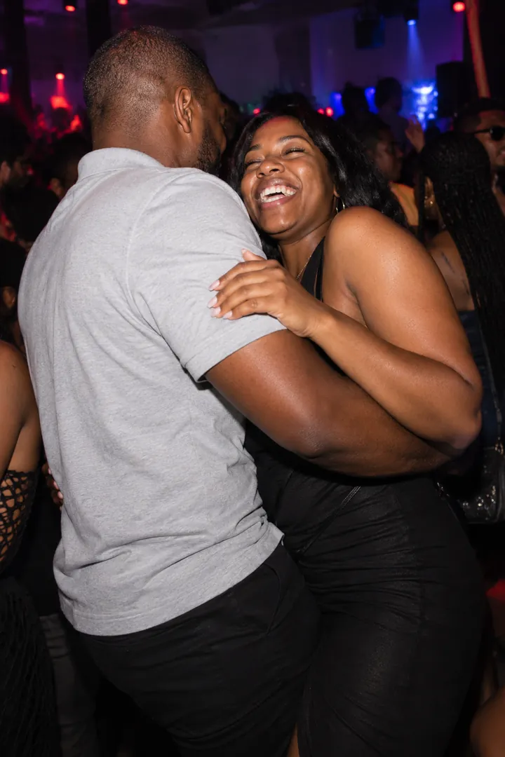 A man in a grey shirt dancing beside a smiling woman.