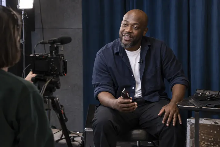A barber speaking on camera during a recorded interview