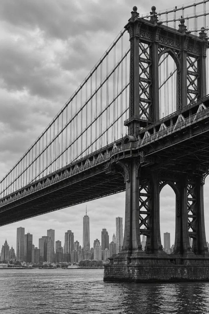 A black and white view of a New York suspension bridge.